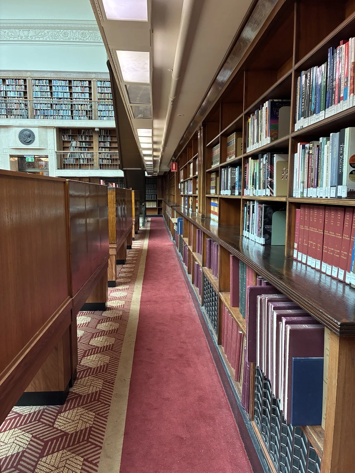 高い木製書架に本が並ぶミッチェル図書館の通路