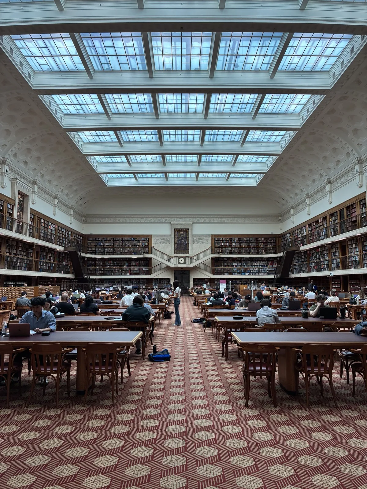 大きな天窓と木製の閲覧机が並ぶミッチェル図書館閲覧室